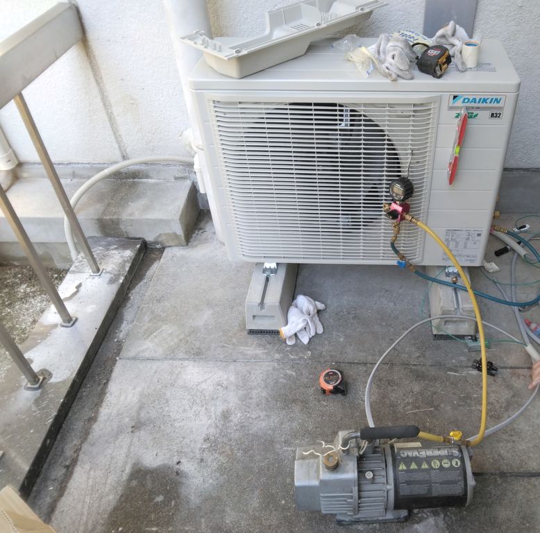 室外機に真空ポンプとゲージをつないだ点検・据え付けの作業